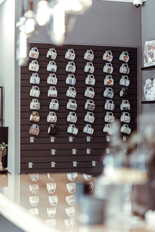 Wand mit vielen individuell bedruckten Tassen im Laden